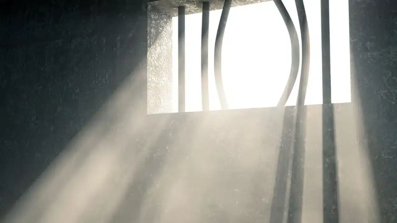 Prison bars pulled open with sunlight streaming in